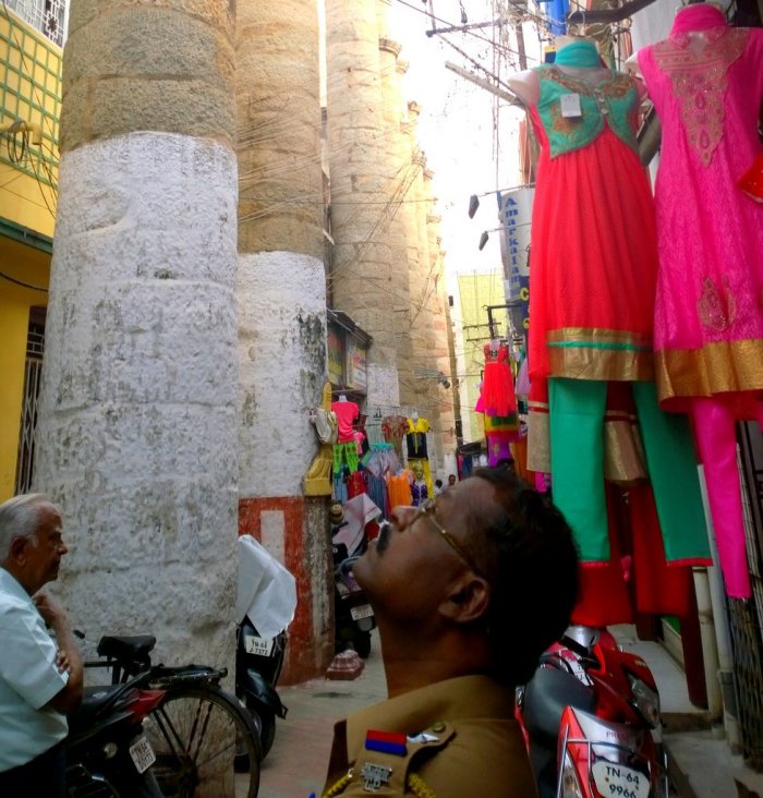 A policeman looks up in awe at the Pathu Thoongal or 10 pillars, which are the only things remaining from the Ranga Vilas, a palace built by Thirumalai Nayak